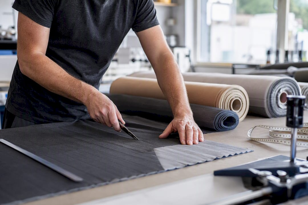 Hände, die im Workshop Plissee-Stoff zuschneiden